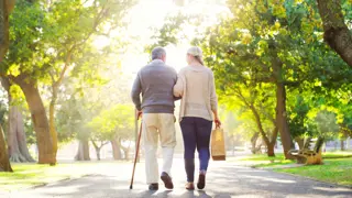 Man with COPD being cared for on a walk by his daughter
