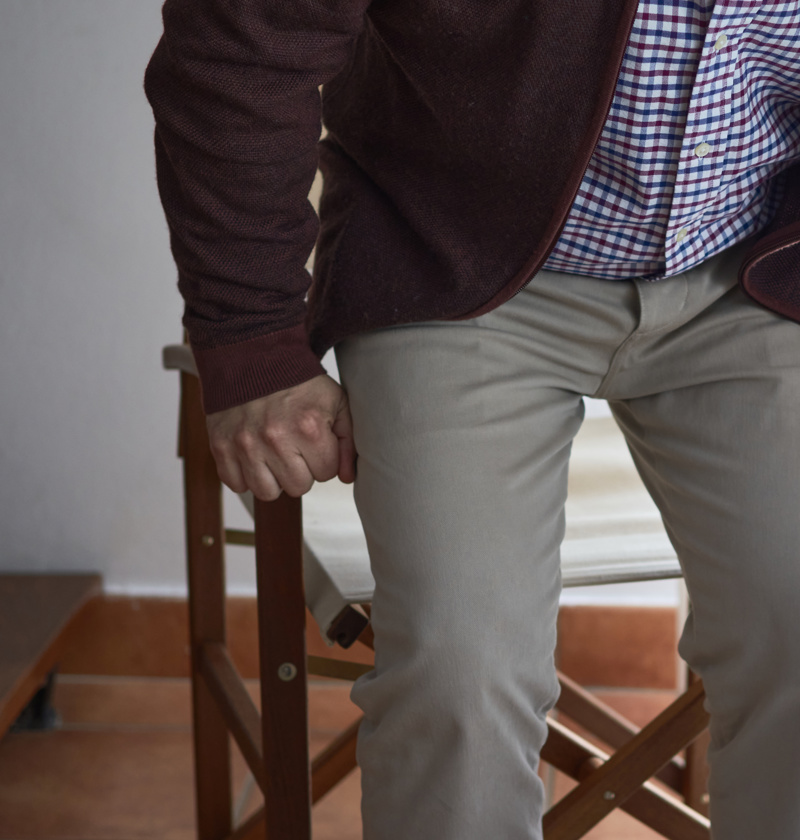 Older adult standing up from a chair, hands gripping the armrests for support – a common scenario for using fall sensor pads to detect instability and help prevent accidents at home.