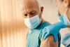 Older man receiving shingles vaccine from a healthcare worker — shingles vaccination may help reduce dementia risk