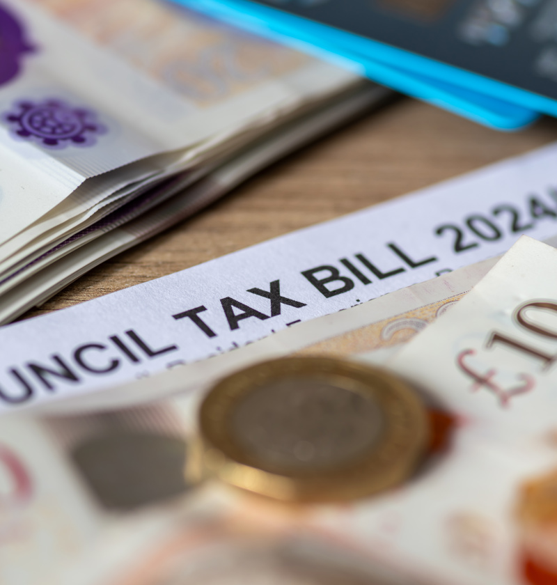 A close-up of a UK council tax bill for 2024/25, with twenty-pound notes and coins. A representation of financial planning, tax reductions, and support schemes for carers and elderly parents.