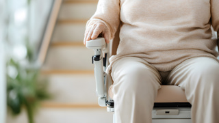 Elderly person on a stairlift. A home modification option for your elderly parent.