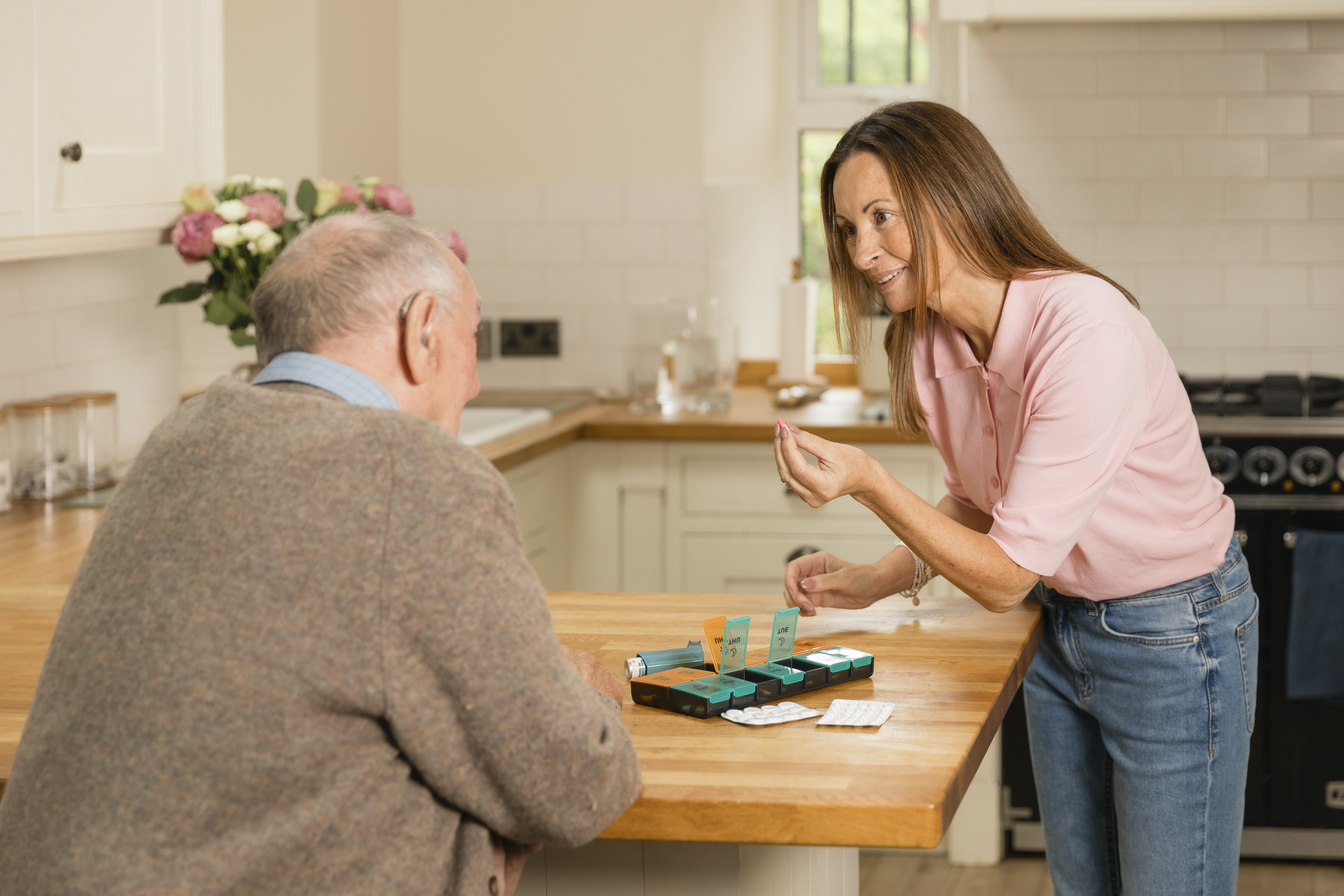 Carent looking after their elderly parent, holding a bag of medication