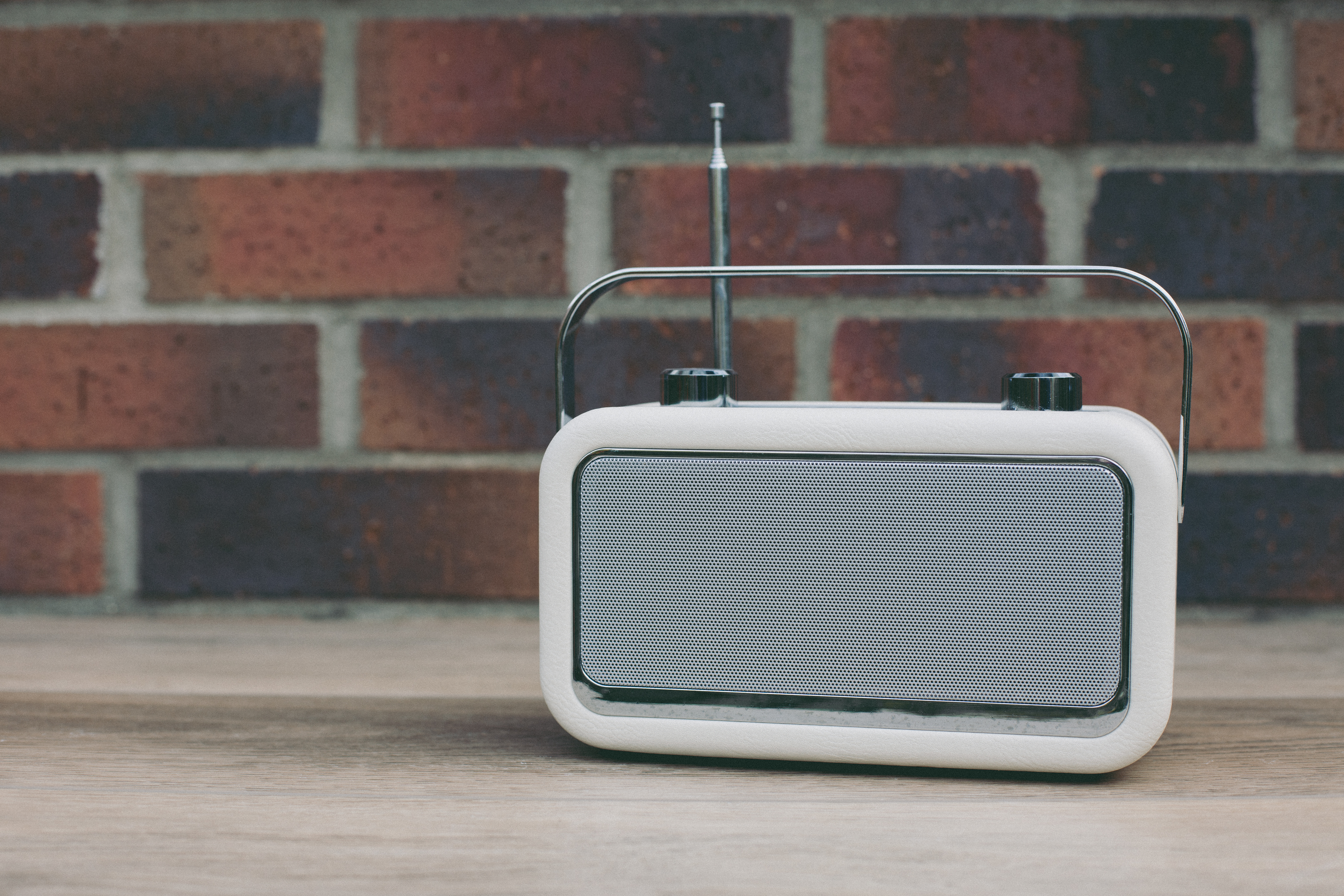 Simple digital radio music player on a wooden table – easy-to-use music players support elderly parents with dementia by offering familiar sounds, soothing routines, and a sense of connection.