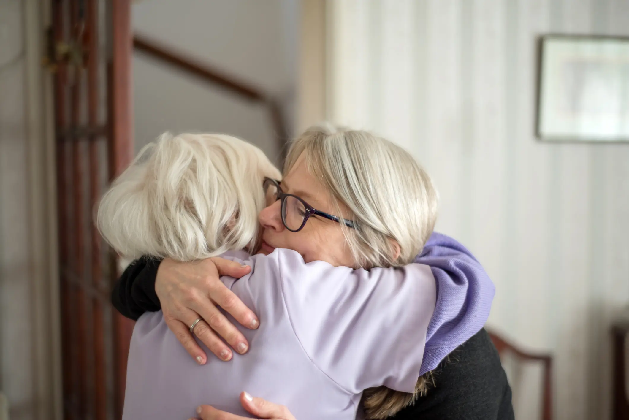 A middle aged woman hugging her elderly parent