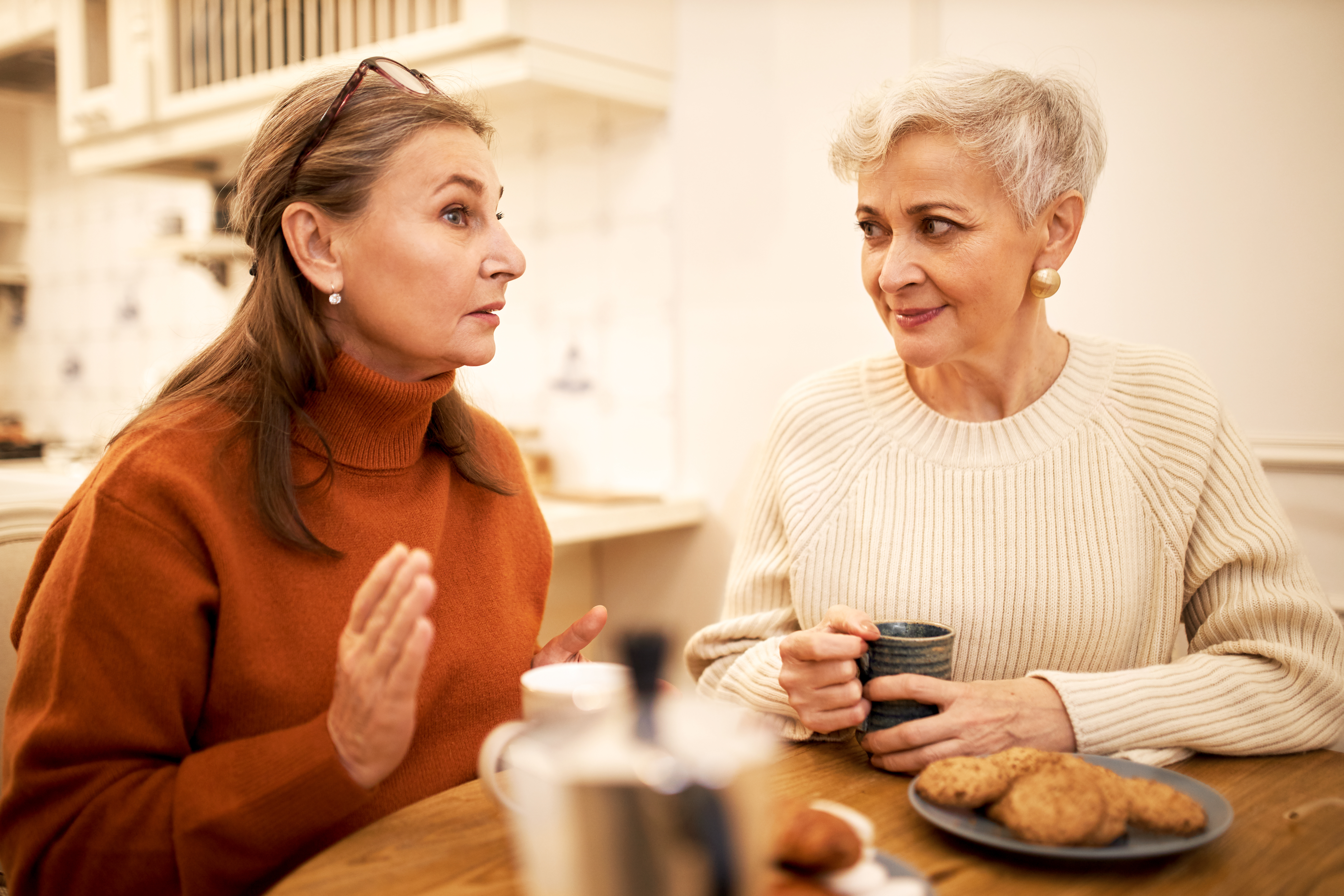 Two siblings who are carents discussing how to care for their elderly parents