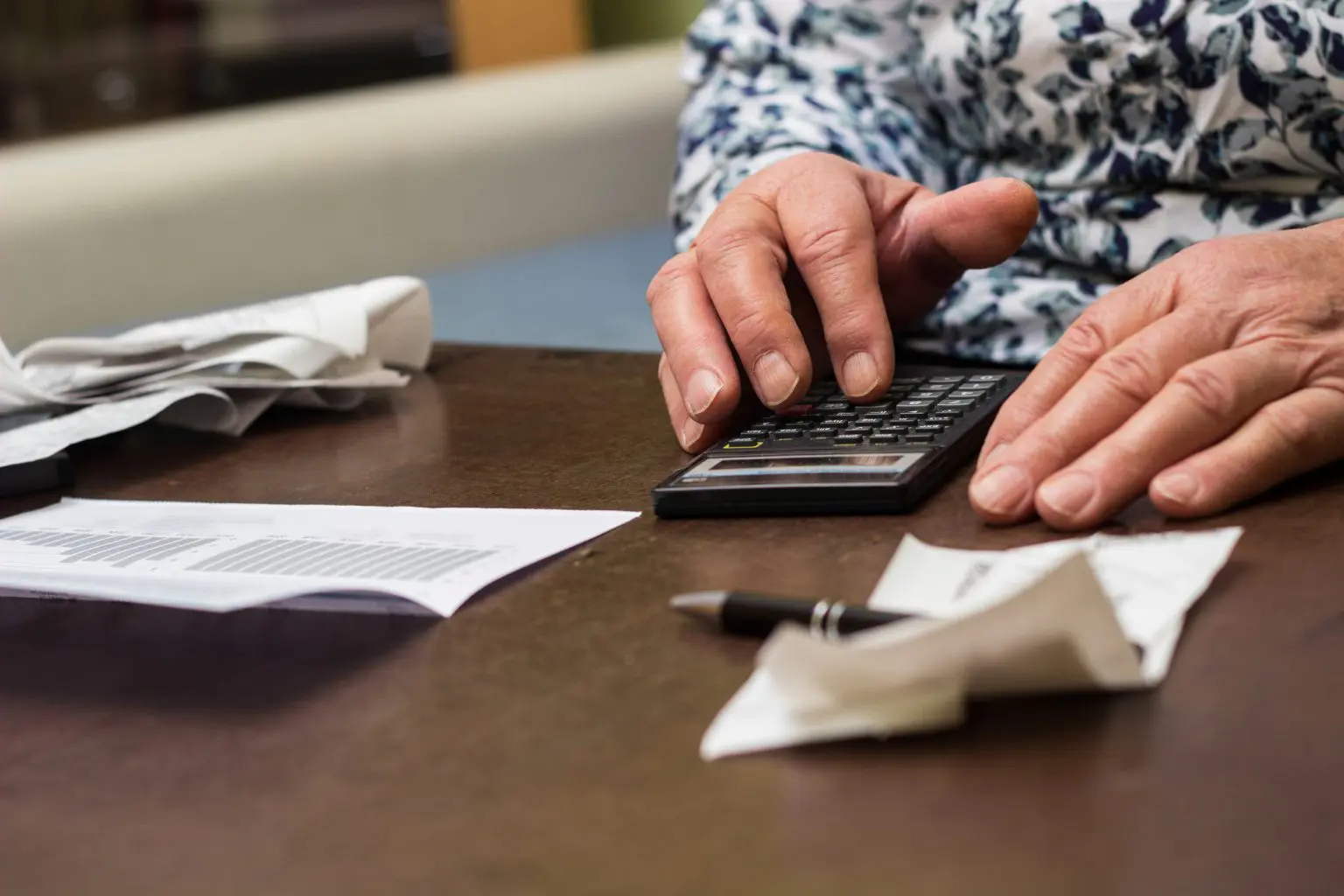 Middle aged man calculating how much caring for elderly parent in care services will cost
