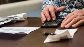 Middle aged man calculating how much caring for elderly parent in care services will cost