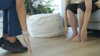 An older person and a physiotherapist reaching their arms to the ground