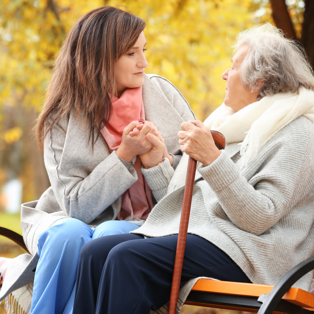 Carent and their elderly parent sitting on a bench