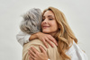 A picture of a woman and her elderly mother, both smiling at the camera. The woman cares for her elderly parent and has written a letter to her