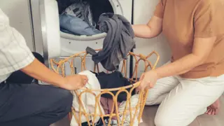 Two women loading washing into a washing machine